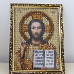 Pu&ograve; includere: Un'icona incorniciata di Ges&ugrave; Cristo con una croce dietro di lui e un libro nelle sue mani. Il libro &egrave; aperto e il testo dice "ПРІНДИТЕ КОЙ ВЫСОЗНИТЕ ИНЪ ВСИ ТЕХ ИГО ЖОВ на СЕБЕ ИЛЮЗИ WEPOMENEN TECH WING ИИЗА УПОКОЙ АКО КРОТКЪ".