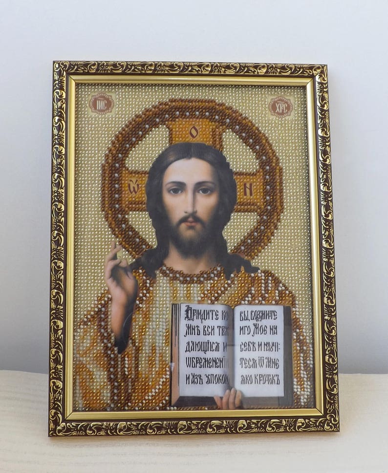 Pu&ograve; includere: Un'icona incorniciata di Ges&ugrave; Cristo con una croce dietro di lui e un libro nelle sue mani. Il libro &egrave; aperto e il testo dice "ПРІНДИТЕ КОЙ ВЫСОЗНИТЕ ИНЪ ВСИ ТЕХ ИГО ЖОВ на СЕБЕ ИЛЮЗИ WEPOMENEN TECH WING ИИЗА УПОКОЙ АКО КРОТКЪ".