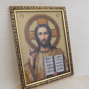 Pu&ograve; includere: Un'icona religiosa incorniciata che raffigura Ges&ugrave; Cristo che tiene un libro aperto. L'icona &egrave; fatta di perline e ha una cornice dorata con dettagli decorativi. Il testo sul libro recita "Придите ко мне все труждающиеся и обремененные, и Я успокою вас."