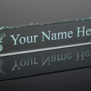 May include: A clear glass desk nameplate with a frosted deer silhouette and the text "Your Name Here" engraved on the front.