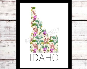 May include: A printable art print featuring a floral pattern in the shape of the state of Idaho. The print is on a white background with the word "IDAHO" printed in black below the state outline.