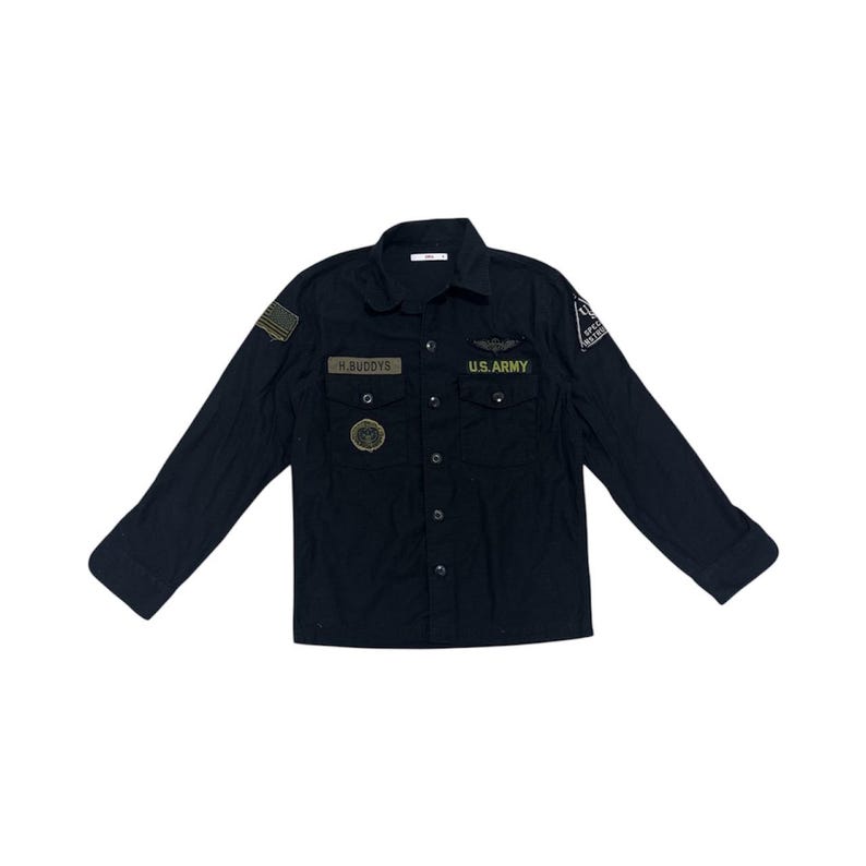 Pode incluir: Camisa preta de manga comprida com patches e ins&iacute;gnias de estilo militar. Apresenta uma etiqueta com o nome "H. BUDDYS" e "U.S. ARMY" acima dos bolsos. A camisa tem gola e punhos abotoados.