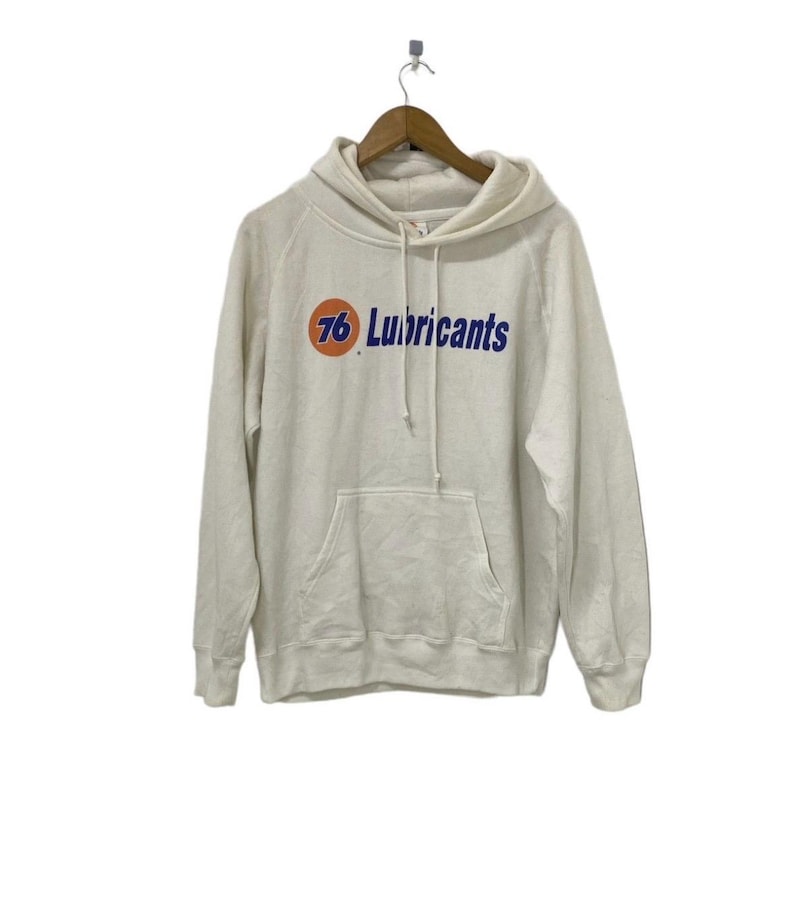 Puede incluir: Una sudadera con capucha blanca con un logotipo azul y naranja que dice "76 Lubricants".