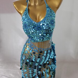 May include: A blue sequined halter top and matching skirt with fringe. The top has a V-neckline and the skirt is a wrap style.
