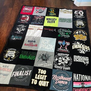 May include: A patchwork quilt made from t-shirts, with a black border. The t-shirts feature text and graphics related to dance and competitions. The quilt is a collection of memories, with a black backing.