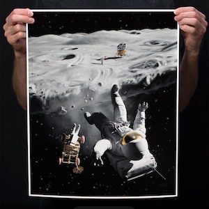 May include: A fine art print of an astronaut falling into space, with a lunar lander and a figure in the distance. The print is 16x20 inches and features a black background with white and gray details.