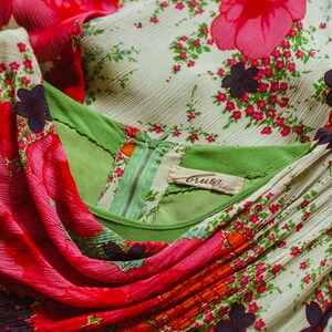 May include: A white dress with a green bodice and a pink floral print. The dress has a zipper closure and a label that reads "Bruiser."