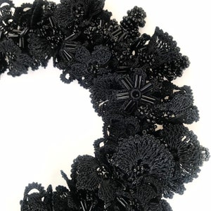 May include: Black crocheted lace trim with black beads and star-shaped embellishments.