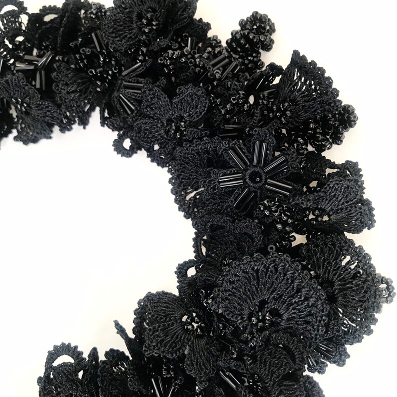 May include: Black crocheted lace trim with black beads and star-shaped embellishments.