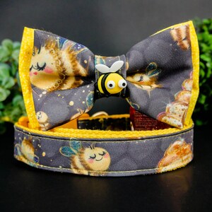 Pode incluir: Um laço de gravata de abelha amarelo e preto com um colar de tecido preto e dourado. O laço de gravata tem um design de abelha com uma abelha amarela e preta na frente. O colar tem um design de abelha com uma abelha amarela e preta na frente.