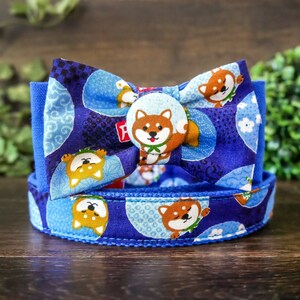 May include: Blue and white dog-themed bow tie with a blue and white patterned collar. The bow tie features a variety of cartoon dogs with different expressions.