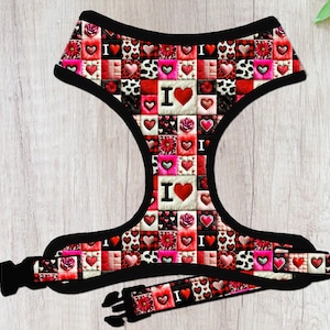 May include: A red, pink, and black dog harness with a repeating pattern of hearts and the words "I Love" printed on it.