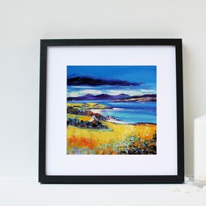 May include: Framed painting of a seascape with a blue sky, white clouds, and a yellow grassy field in the foreground. The painting is in a black frame.
