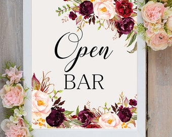 May include: White framed sign with a floral design in shades of burgundy, pink, and green. The sign says "Open Bar" in black text.