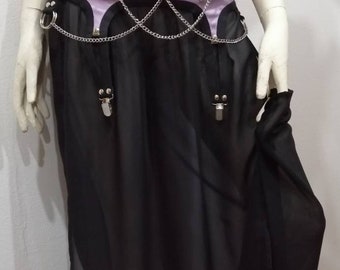 May include: A black corset top with a front lace-up detail paired with a lavender waist belt featuring silver-toned metal rings and hanging chains. The ensemble includes a sheer black skirt with attached garter clips and silver hardware accents.
