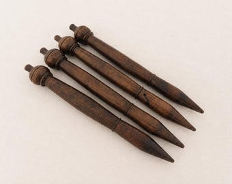 May include: Four dark brown wooden tools with a tapered, pointed end and a rounded, knob-like handle. Each tool features a smooth, cylindrical body with a distinct turned wood design, showcasing a rich, deep brown grain and a polished finish.