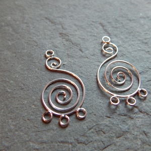 May include: Two silver wire earrings with a spiral design and dangling loops.