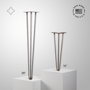 May include: Two metal hairpin table legs. One leg is 28 inches tall, the other is 16 inches tall. The legs are made of metal with a dark, aged finish. The image includes the text "OHIO MADE IN THE U.S.A."