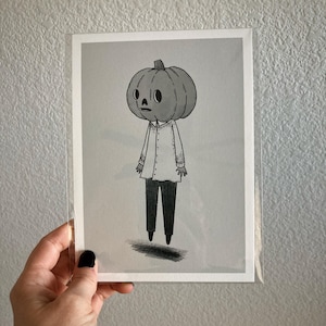 May include: Black and white illustration of a character with a pumpkin head, wearing a button-down shirt and black pants. The artwork is in a minimalist style, with a shadow beneath the character's feet.