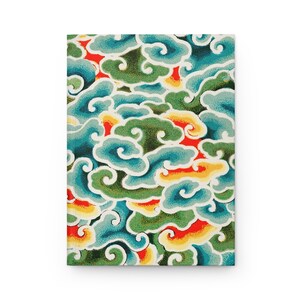 May include: A notebook cover with a repeating pattern of stylized clouds in shades of blue, green, yellow, and red.