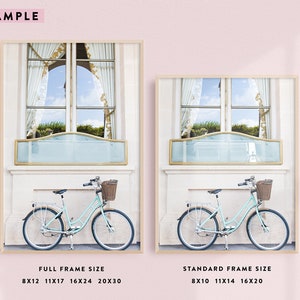 May include: Two framed prints showcasing a light blue bicycle with a wicker basket parked in front of a window. The window has a light blue panel and gold trim. The prints are labeled with frame sizes.