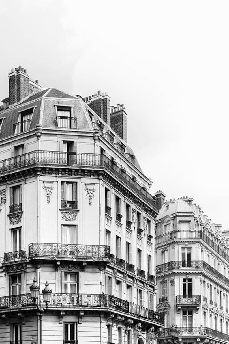May include: Black and white photo of a Parisian building with a sign that reads "Hotel Normandy".