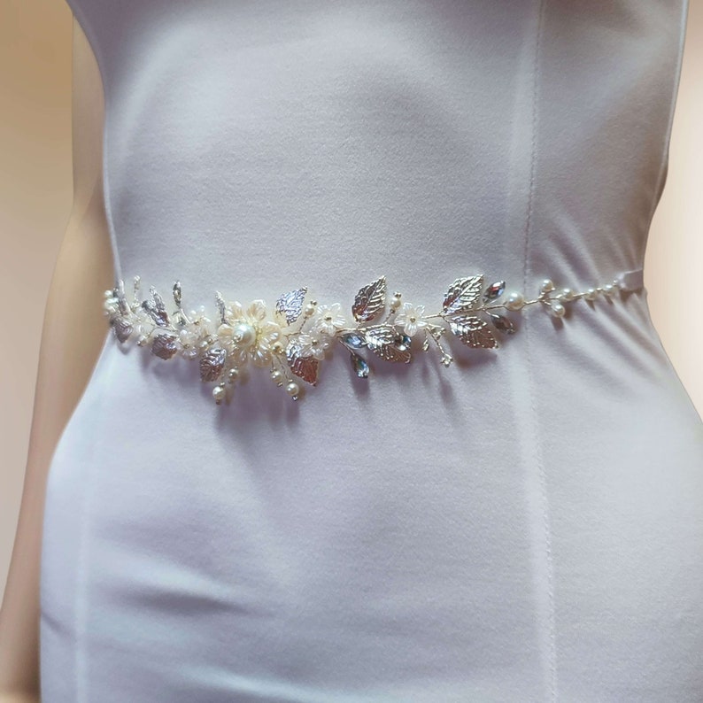 Ceinture florale pour robe de mariage avec fleurs acryliques, perles nacrées en verre, strass, perles de rocailles et feuilles argentées en laiton