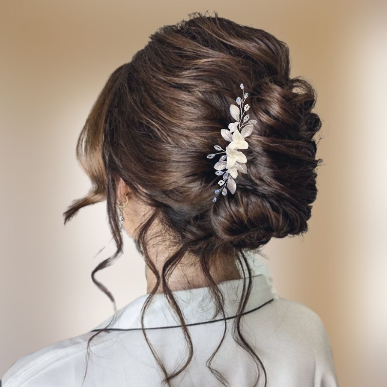 Peigne à cheveux floral avec fleurs blanches et feuilles argentées en porcelaine froide, cristal et strass transparent et perles de rocailles pour chignon ou coiffure de mariage bohème champêtre chic