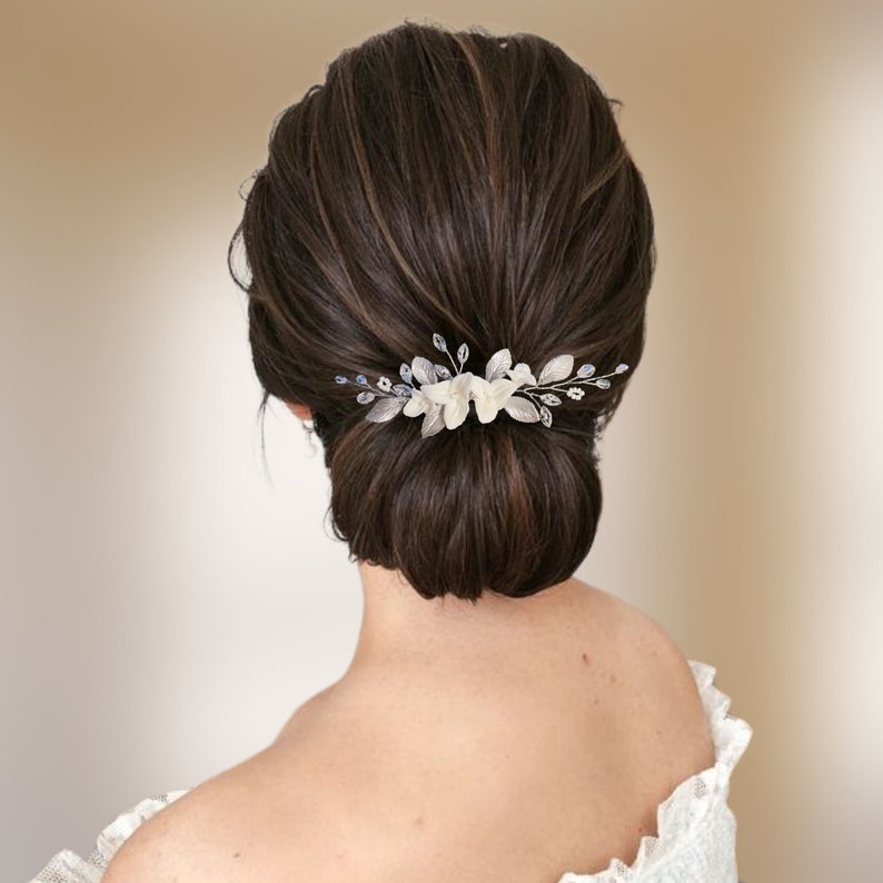 Peigne à cheveux floral avec fleurs blanches et feuilles argentées en porcelaine froide, cristal et strass transparent et perles de rocailles pour chignon ou coiffure de mariage bohème champêtre chic