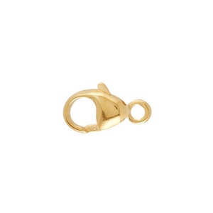 Könnte beinhalten: Goldfarbener Karabinerverschluss mit Federring. Dieser Verschluss wird häufig für Halsketten, Armbänder und anderen Schmuck verwendet.