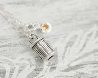 以下が含まれることがあります： 糸巻きチャームと小さな黄色の宝石が付いたシルバーネックレス
