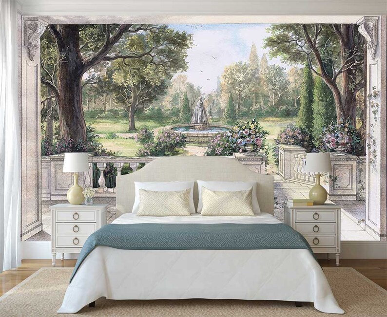 May include: A white bed with a teal blue bedspread sits in front of a wall mural depicting a garden scene with a fountain and trees. Two white nightstands with drawers are on either side of the bed.