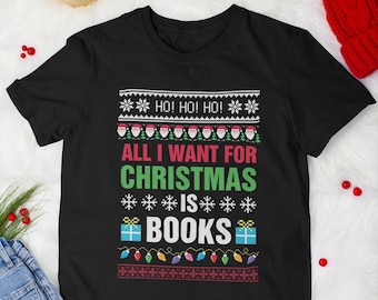May include: Black t-shirt with a Christmas-themed design. The text reads "HO! HO! HO! ALL I WANT FOR CHRISTMAS IS BOOKS" with a snowflake pattern and a gift box with a book inside.