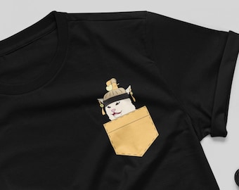 May include: Black t-shirt with a pocket featuring a white cat wearing a gold crown and a surprised expression. The cat is peeking out of the pocket.