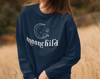 May include: A navy blue sweatshirt with a white crescent moon, stars, and a flower design. The text "moonchild" is written in white below the design.