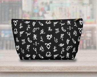 May include: Black zippered pouch with a white pattern of runes and symbols. The pouch is made of fabric and has a zipper closure.