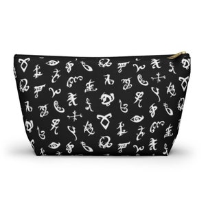 May include: Black zippered pouch with a white pattern of runes and symbols.