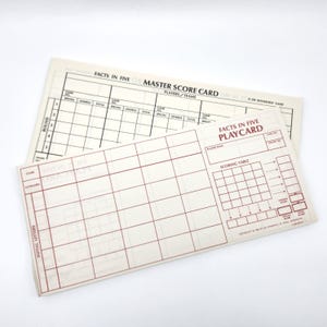 May include: Two vintage "Facts in Five" game score cards. One is a master score card, and the other is a play card. The cards are cream-colored with red and black printed text and grid lines. The play card has a scoring table.