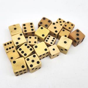 May include: A collection of vintage dice in various shades of cream and tan, with black dots indicating the numbers. The dice are scattered, showcasing their different sides and dot arrangements. A classic game accessory.