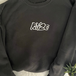 May include: Black sweatshirt with a white embroidered design that says "DO IT 23".