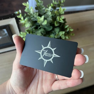Luxury engraved stainless steel business card in matte black finish.