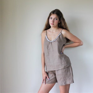 May include: A brown linen pajama set with a white trim on the top. The top is a sleeveless tank top and the shorts are a relaxed fit.
