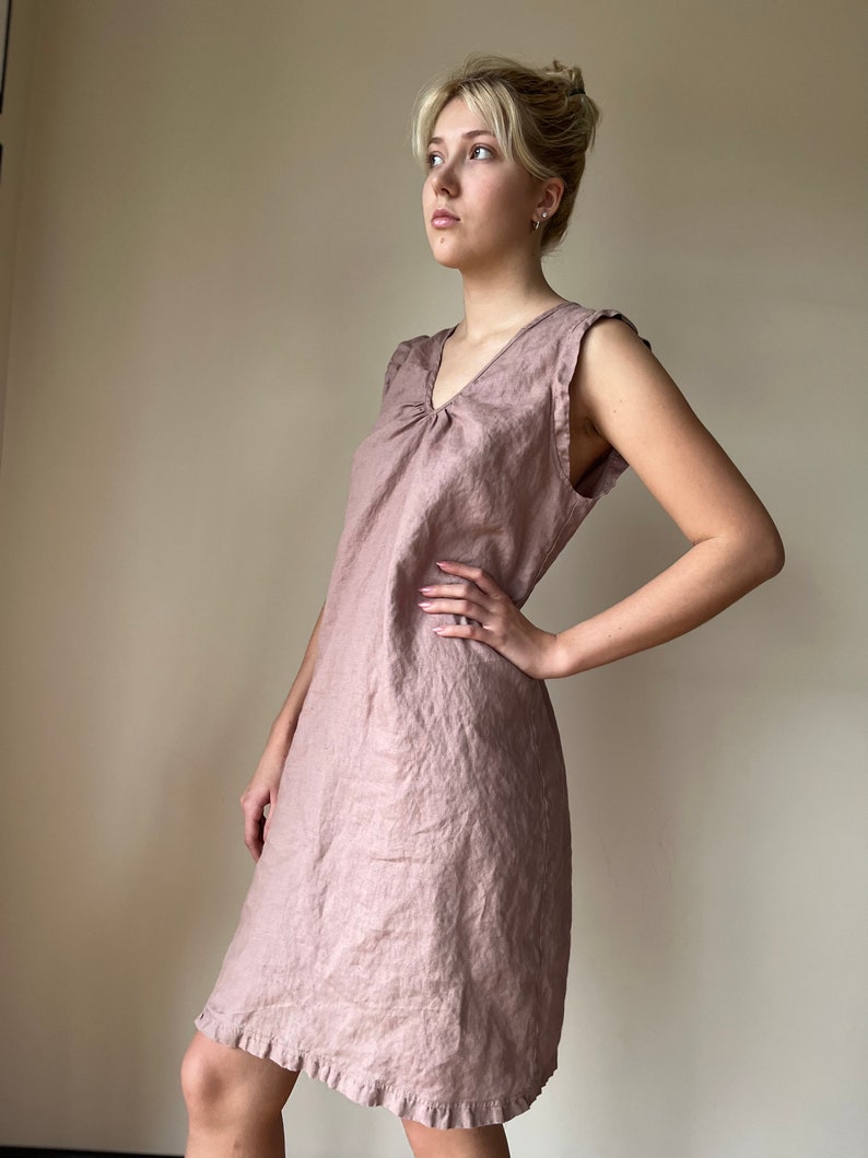May include: A mauve linen dress with a v-neck and a ruffled hem.