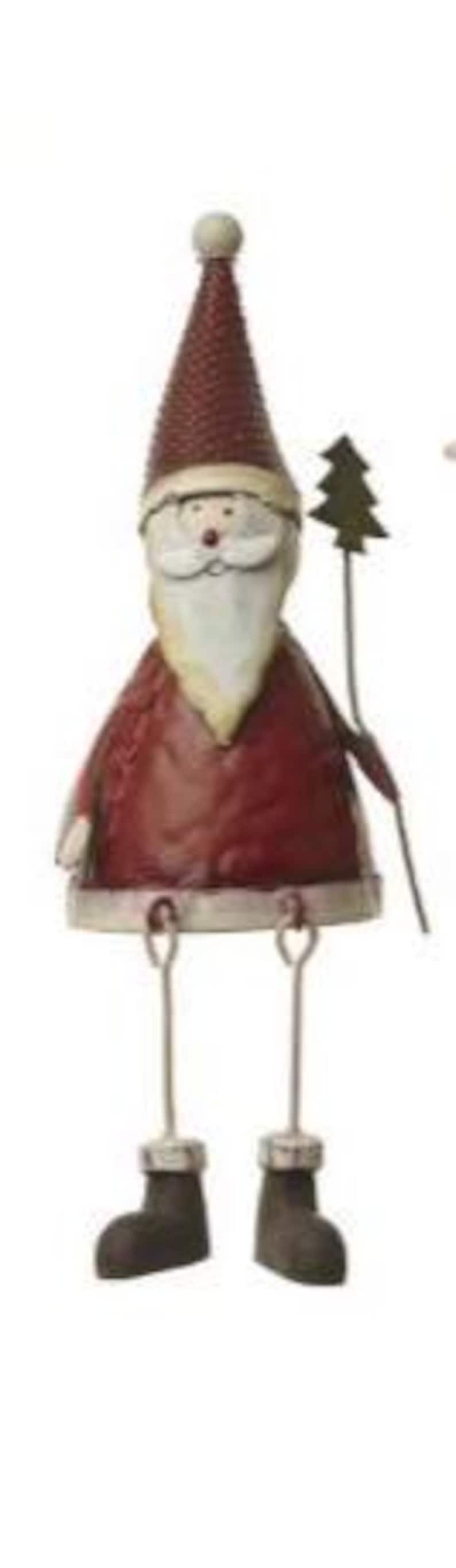 Puede incluir: Figura met&aacute;lica de Pap&aacute; Noel con gorro y abrigo burdeos, barba blanca y botas negras. La figura sostiene un peque&ntilde;o &aacute;rbol de Navidad verde y tiene piernas colgantes. Una decoraci&oacute;n festiva.