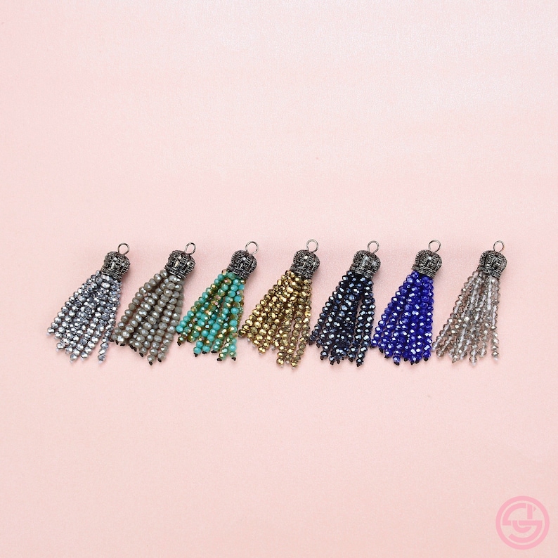 May include: Eight beaded tassels in various colors, including silver, beige, turquoise, gold, dark blue, light blue, and clear. Each tassel has a metal top with a decorative design.