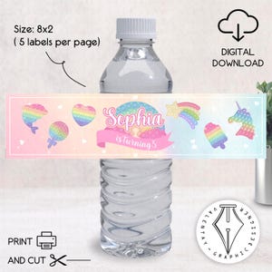 Może przedstawiać: Butelka wody z niestandardową etykietą z napisem "Sophia" i frazą "is turning 5". Etykieta zawiera kolorową grafikę delfina, serca, gwiazdy i jednorożca. Etykieta ma wymiary 20,3 x 5,1 cm i jest przeznaczona do pobrania cyfrowego.