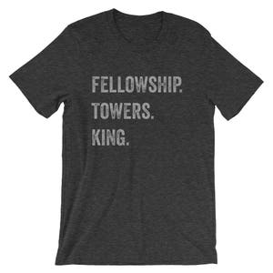 May include: A dark gray t-shirt with the text "FELLOWSHIP TOWERS. KING." printed in white.