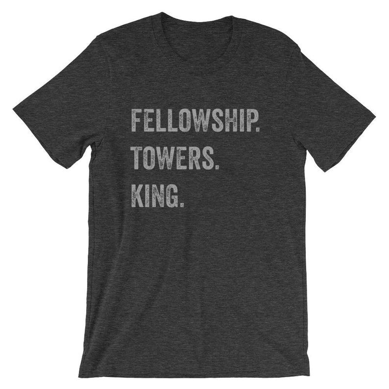 May include: A dark gray t-shirt with the text "FELLOWSHIP TOWERS. KING." printed in white.