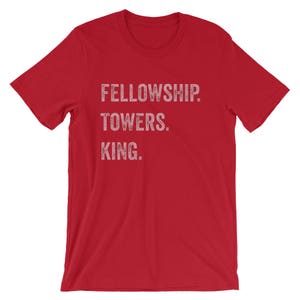 May include: Red short-sleeved t-shirt with white text that reads "FELLOWSHIP. TOWERS. KING."