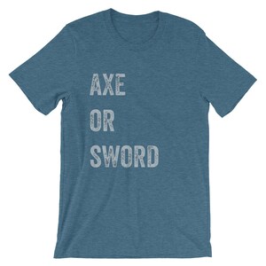 Puede incluir: Una camiseta azul con el texto "AXE OR SWORD" impreso en blanco.